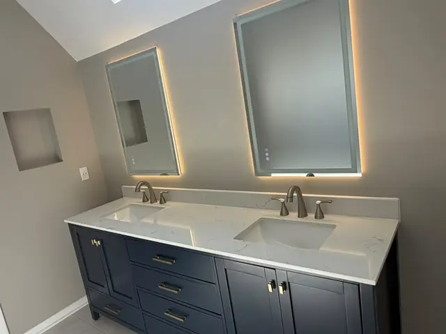 Navy double vanity with backlit mirrors