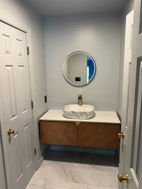 Powder room with vessel sink and round mirror