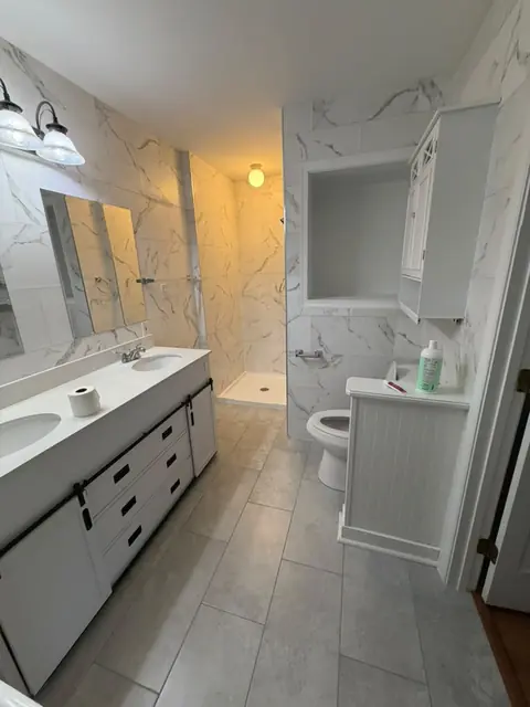 Bathroom with porcelain floor tile and marble-look walls