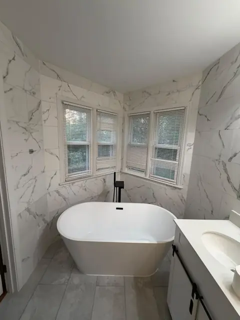 Freestanding tub with marble-look tile walls
