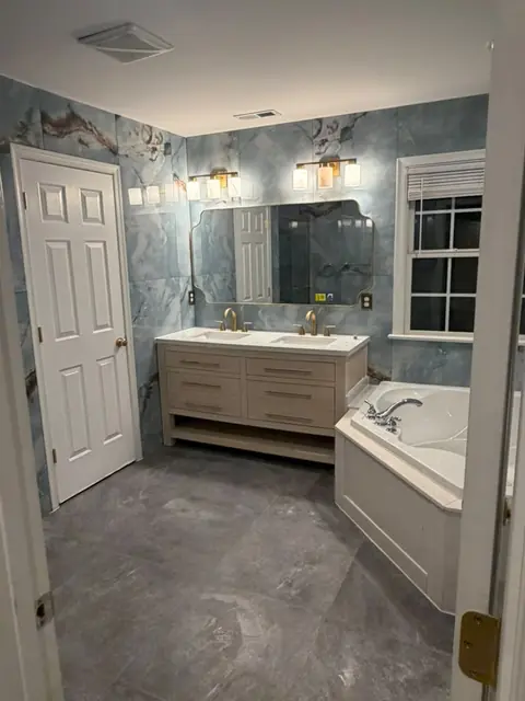 Bathroom with blue marble-look tile walls and corner tub