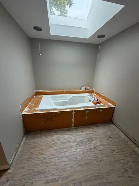 Jetted tub under a skylight with tile floor