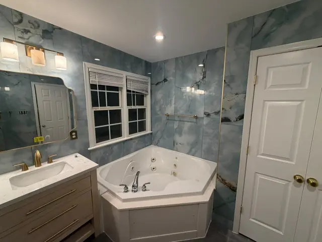 Bathroom with blue marble-look tile and corner jetted tub